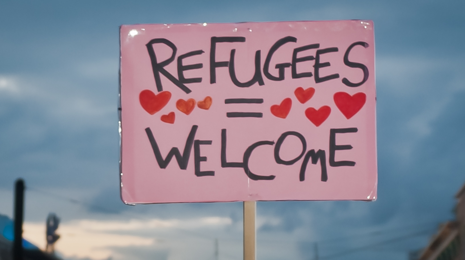 Ein Schild heißt Refugees welcome.